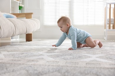 Photo of Cute little baby crawling on floor at home