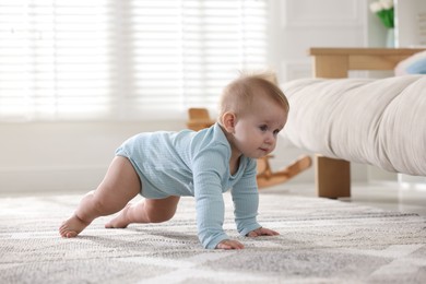 Photo of Cute little baby crawling on floor at home