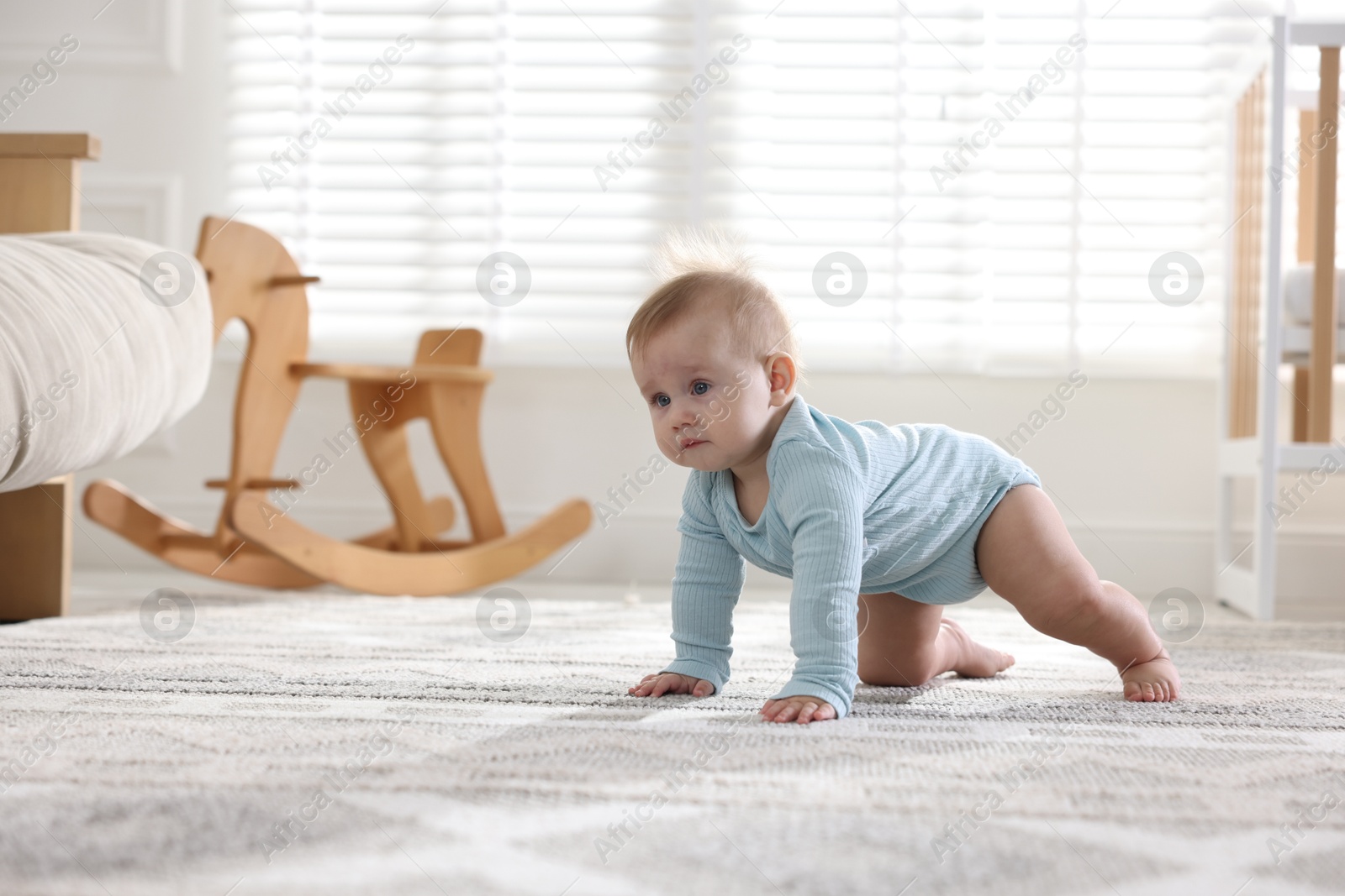 Cute little baby crawling on floor at home, space for text Photo of Cute little baby crawling on floor at home, space for text