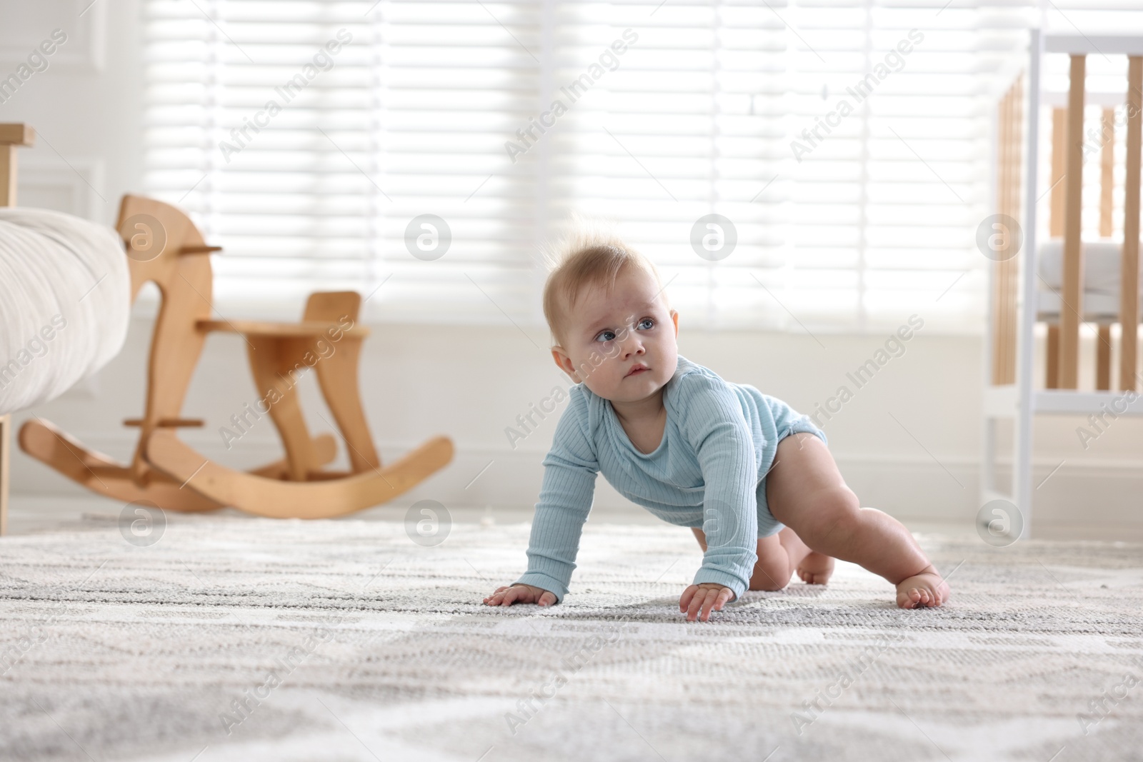 Cute little baby crawling on floor at home, space for text Photo of Cute little baby crawling on floor at home, space for text