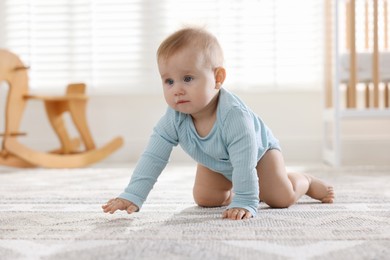 Photo of Cute little baby crawling on floor at home