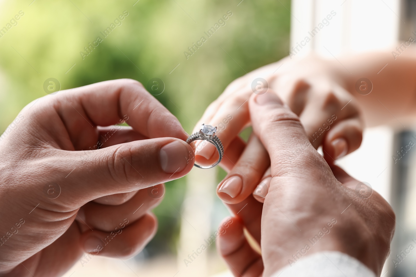 Making proposal. Man putting engagement ring on his girlfriend's finger outdoors, closeup Photo of Making proposal. Man putting engagement ring on his girlfriend's finger outdoors, closeup
