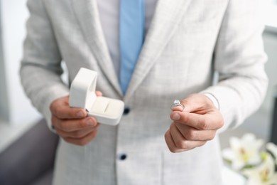 Photo of Making proposal. Man with engagement ring indoors, closeup
