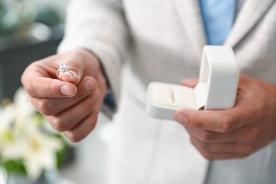 Photo of Making proposal. Man with engagement ring indoors, closeup