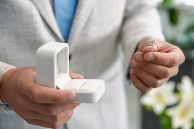 Photo of Making proposal. Man with engagement ring indoors, closeup