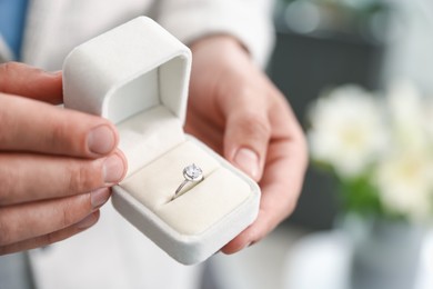 Photo of Making proposal. Man with engagement ring indoors, closeup