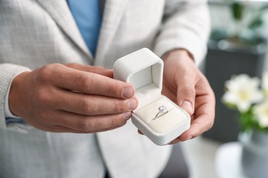 Photo of Making proposal. Man with engagement ring indoors, closeup
