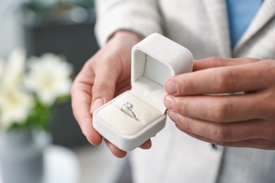 Photo of Making proposal. Man with engagement ring indoors, closeup