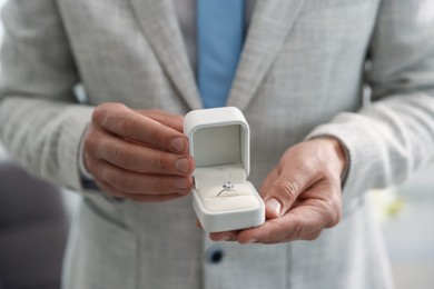 Photo of Making proposal. Man with engagement ring indoors, closeup