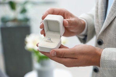 Photo of Making proposal. Man with engagement ring indoors, closeup
