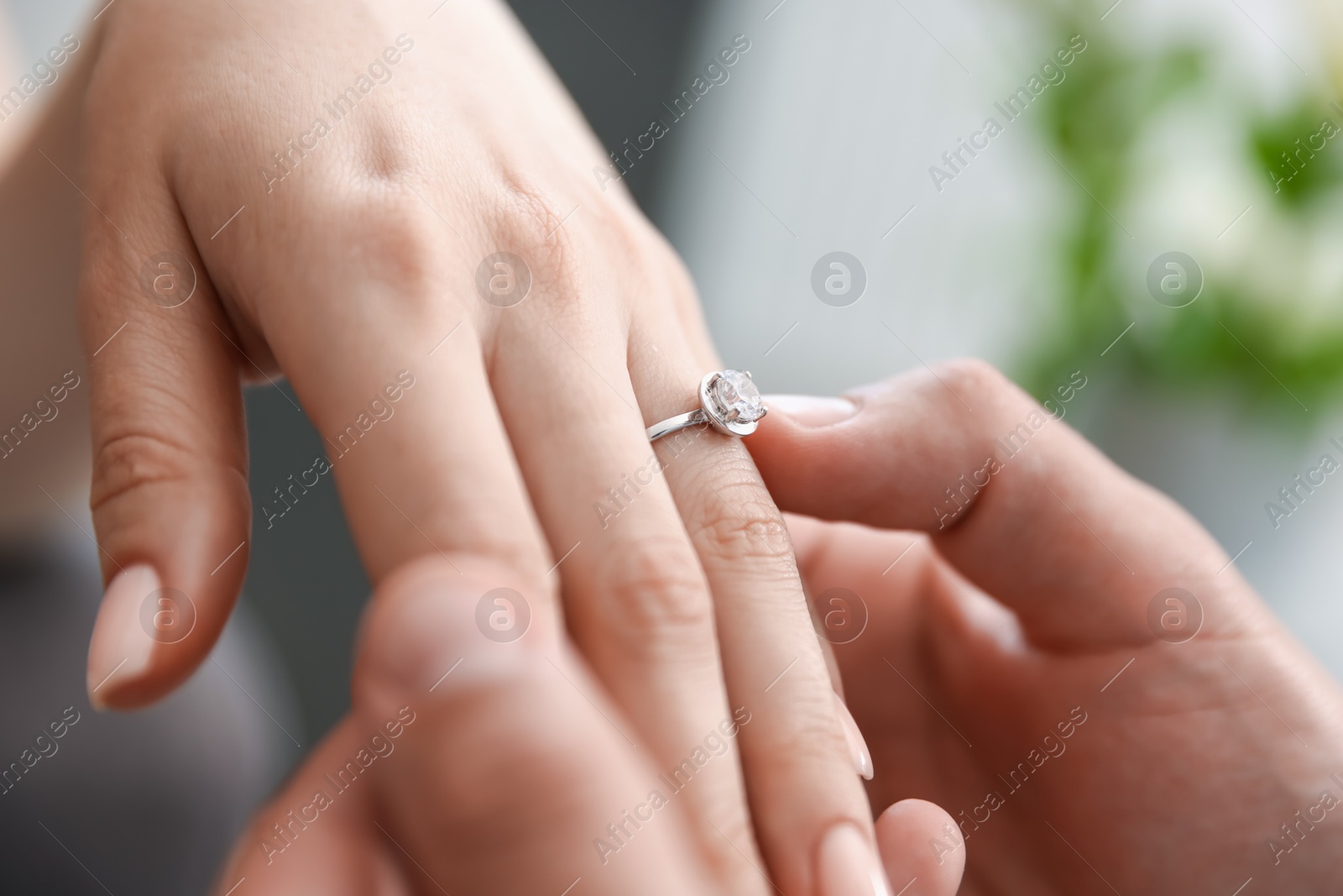 Making proposal. Man putting engagement ring on his girlfriend's finger indoors, closeup Photo of Making proposal. Man putting engagement ring on his girlfriend's finger indoors, closeup