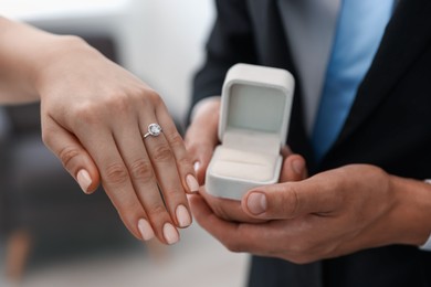 Photo of Making proposal. Woman with engagement ring and her fiance indoors, closeup