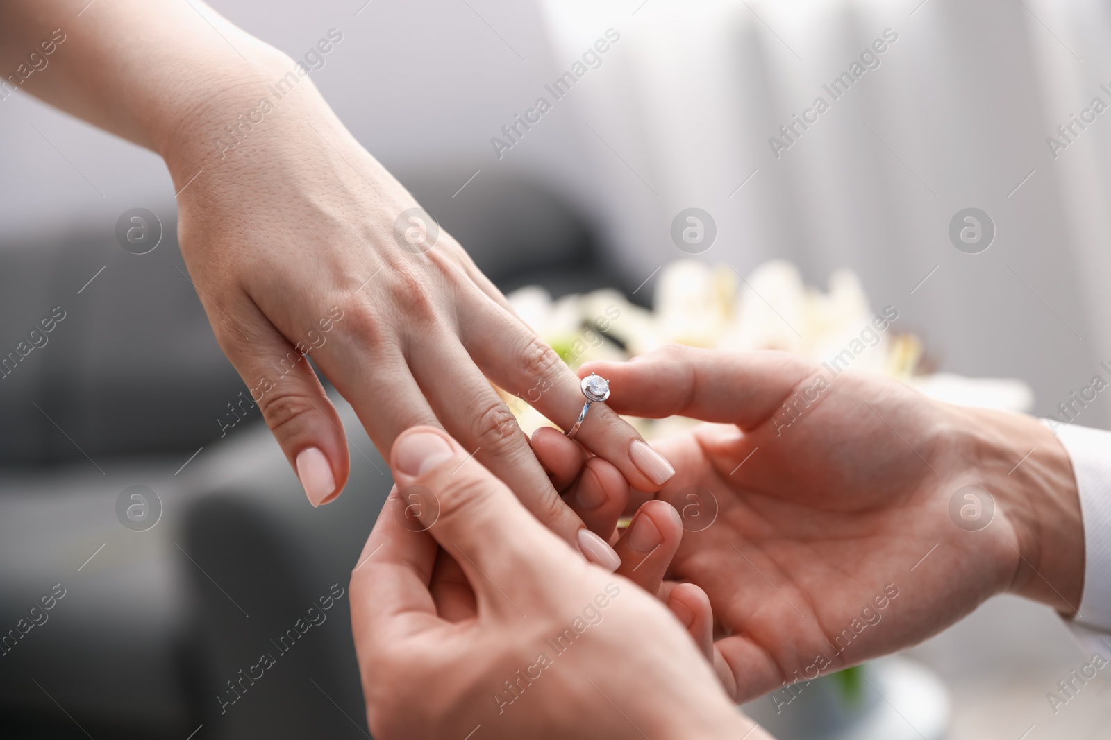 Making proposal. Man putting engagement ring on his girlfriend's finger indoors, closeup Photo of Making proposal. Man putting engagement ring on his girlfriend's finger indoors, closeup