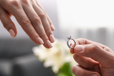 Photo of Man with engagement ring making marriage proposal to his girlfriend indoors, closeup