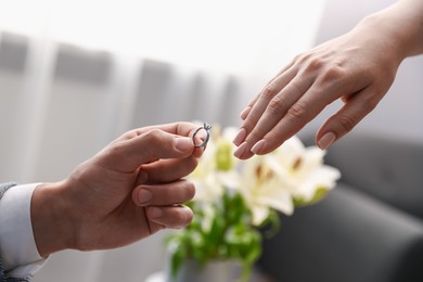 Photo of Man with engagement ring making marriage proposal to his girlfriend indoors, closeup