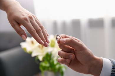 Photo of Man with engagement ring making marriage proposal to his girlfriend indoors, closeup