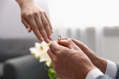 Photo of Man with engagement ring making marriage proposal to his girlfriend indoors, closeup