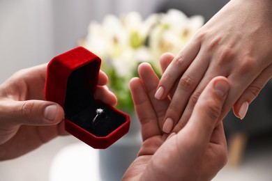Photo of Man with engagement ring making marriage proposal to his girlfriend indoors, closeup