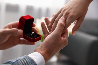 Photo of Man with engagement ring making marriage proposal to his girlfriend indoors, closeup