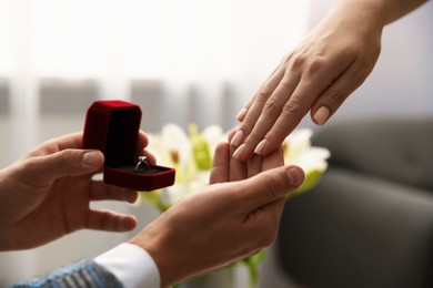 Photo of Man with engagement ring making marriage proposal to his girlfriend indoors, closeup