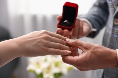 Photo of Man with engagement ring making marriage proposal to his girlfriend indoors, closeup