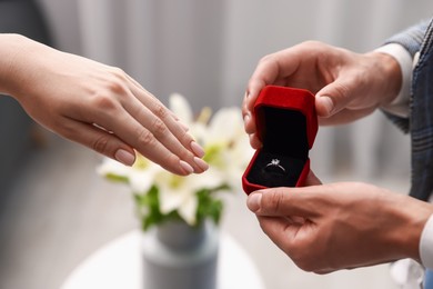 Photo of Man with engagement ring making marriage proposal to his girlfriend indoors, closeup