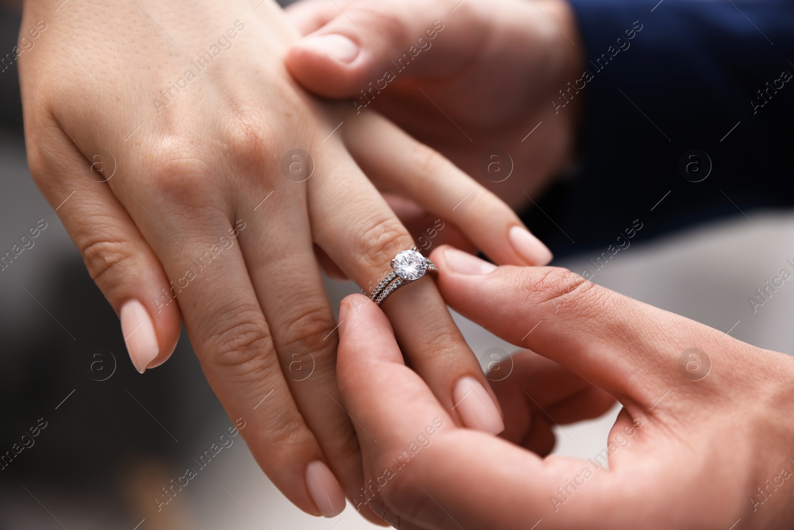 Making proposal. Man putting engagement ring on his girlfriend's finger indoors, closeup Photo of Making proposal. Man putting engagement ring on his girlfriend's finger indoors, closeup