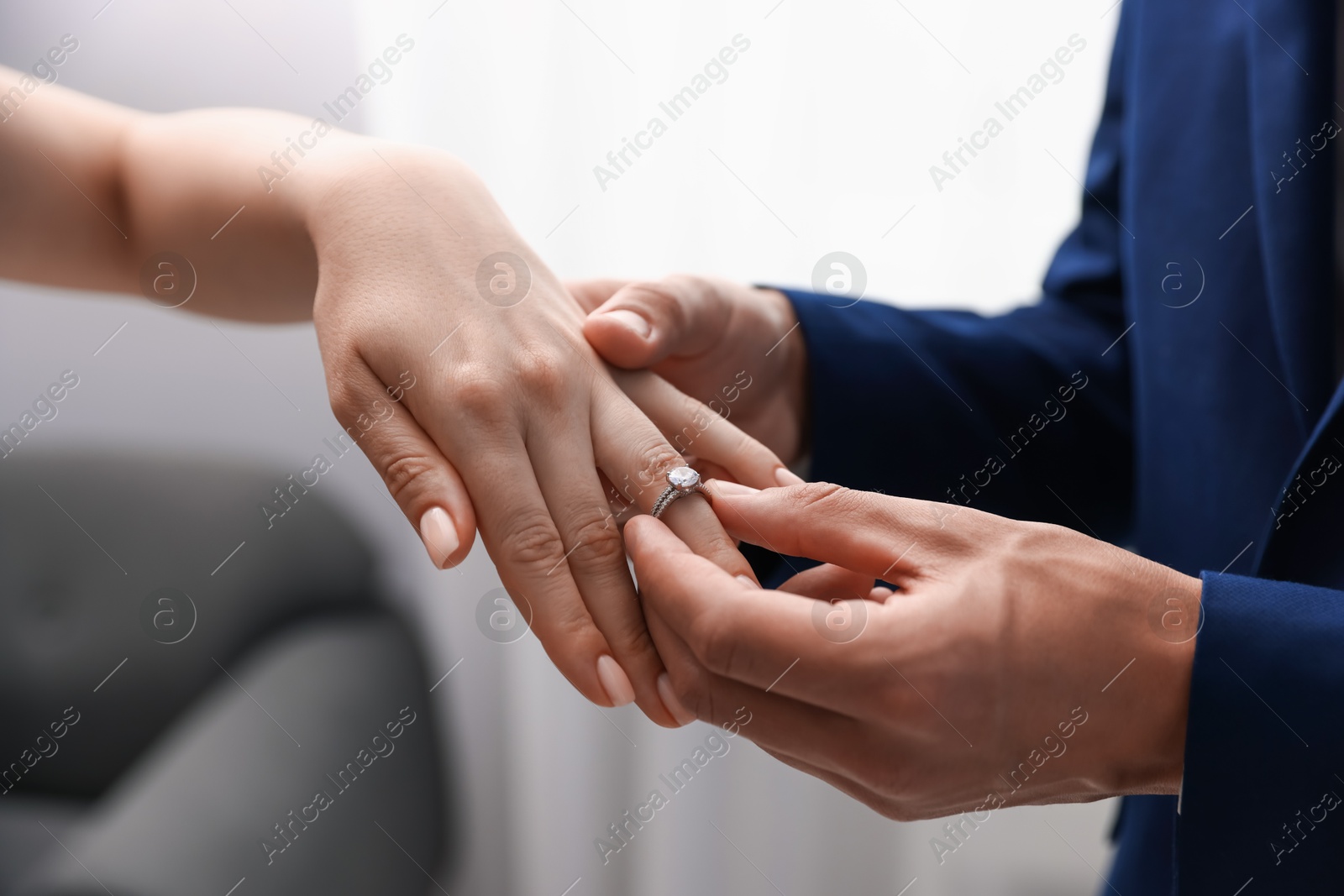 Making proposal. Man putting engagement ring on his girlfriend's finger indoors, closeup Photo of Making proposal. Man putting engagement ring on his girlfriend's finger indoors, closeup