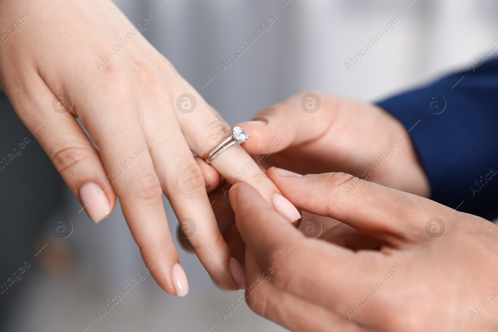 Making proposal. Man putting engagement ring on his girlfriend's finger indoors, closeup Photo of Making proposal. Man putting engagement ring on his girlfriend's finger indoors, closeup