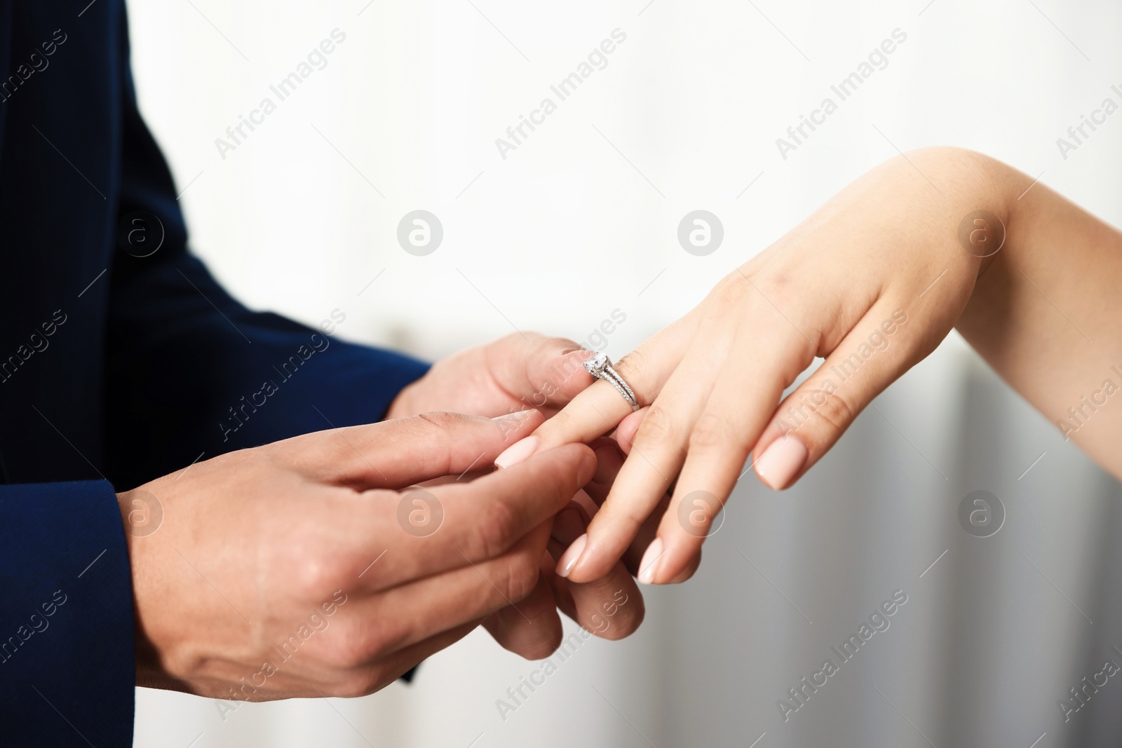 Making proposal. Man putting engagement ring on his girlfriend's finger indoors, closeup Photo of Making proposal. Man putting engagement ring on his girlfriend's finger indoors, closeup