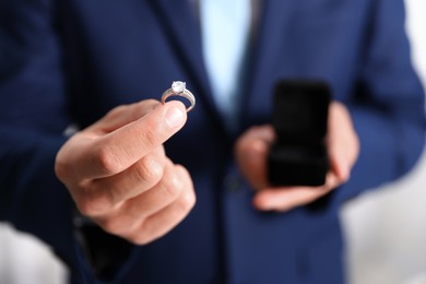 Photo of Making proposal. Man with engagement ring indoors, closeup