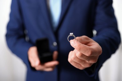 Photo of Making proposal. Man with engagement ring indoors, closeup