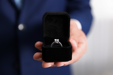 Photo of Making proposal. Man with engagement ring indoors, closeup