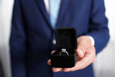 Photo of Making proposal. Man with engagement ring indoors, closeup