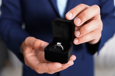 Photo of Making proposal. Man with engagement ring indoors, closeup