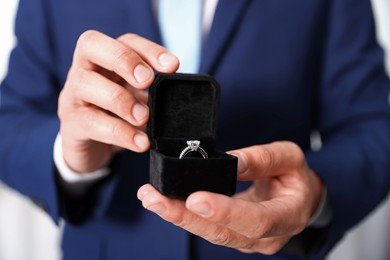 Photo of Making proposal. Man with engagement ring indoors, closeup
