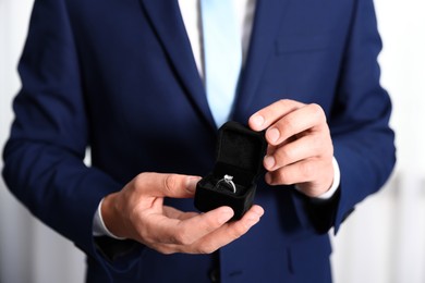 Photo of Making proposal. Man with engagement ring indoors, closeup