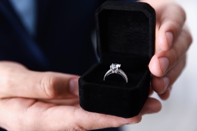 Photo of Making proposal. Man with engagement ring indoors, closeup