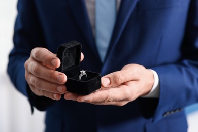 Photo of Making proposal. Man with engagement ring indoors, closeup