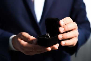 Photo of Making proposal. Man with engagement ring indoors, closeup