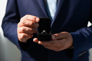 Photo of Making proposal. Man with engagement ring indoors, closeup