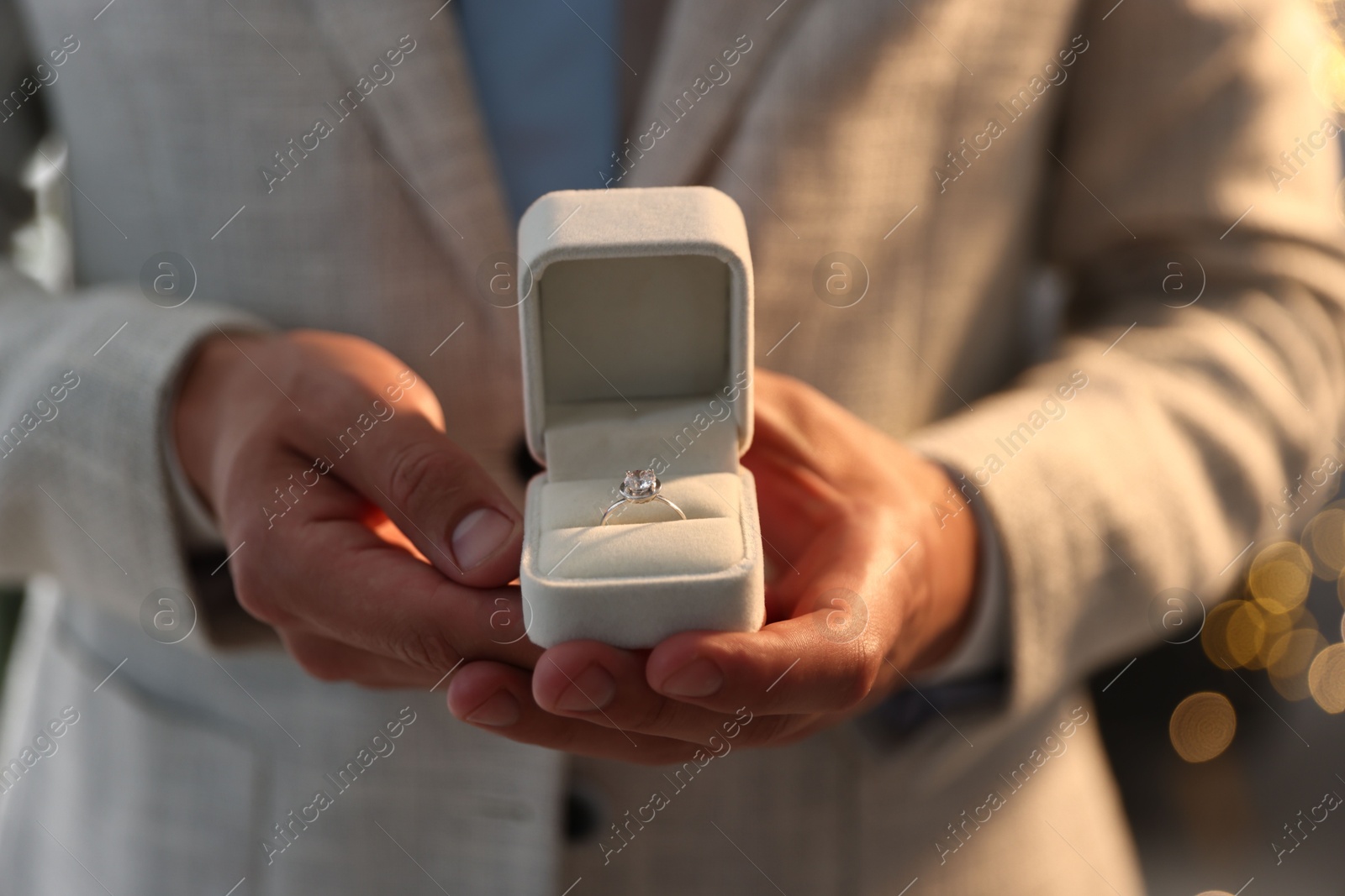 Making proposal. Man with engagement ring indoors, closeup. Bokeh effect Photo of Making proposal. Man with engagement ring indoors, closeup. Bokeh effect