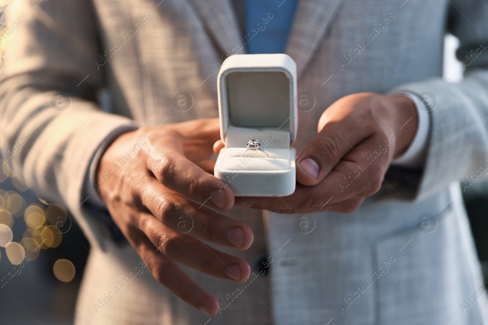 Making proposal. Man with engagement ring indoors, closeup. Bokeh effect Photo of Making proposal. Man with engagement ring indoors, closeup. Bokeh effect