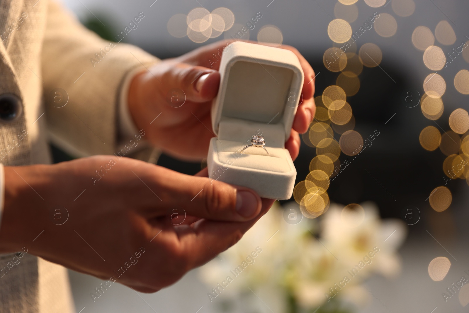 Making proposal. Man with engagement ring indoors, closeup. Bokeh effect Photo of Making proposal. Man with engagement ring indoors, closeup. Bokeh effect