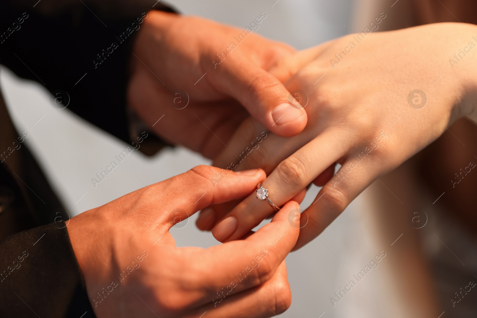 Making proposal. Man putting engagement ring on his girlfriend's finger indoors, closeup Photo of Making proposal. Man putting engagement ring on his girlfriend's finger indoors, closeup