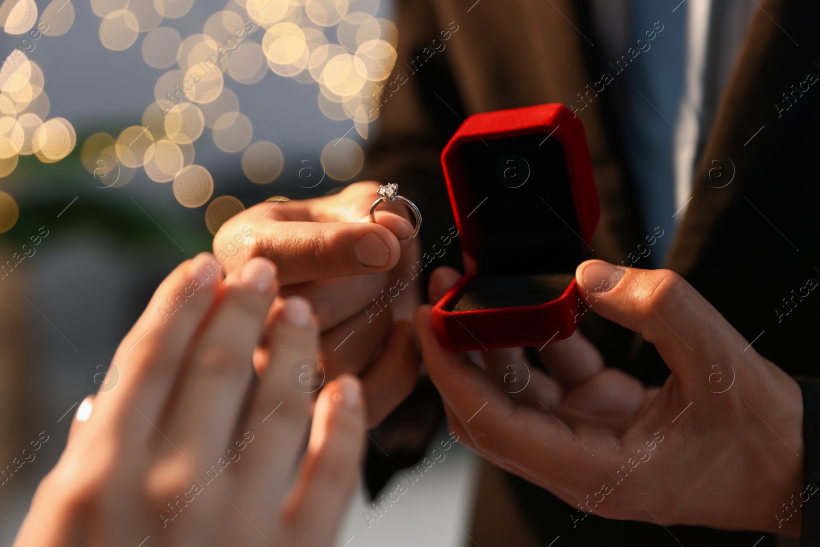 Man with engagement ring making marriage proposal to his girlfriend indoors, closeup. Bokeh effect Photo of Man with engagement ring making marriage proposal to his girlfriend indoors, closeup. Bokeh effect