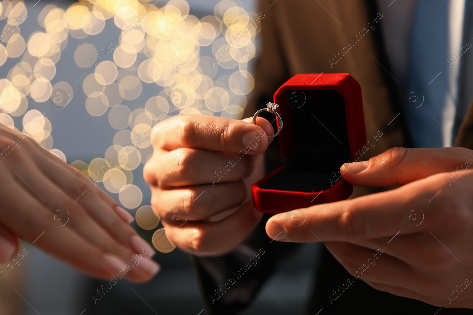 Man with engagement ring making marriage proposal to his girlfriend indoors, closeup. Bokeh effect Photo of Man with engagement ring making marriage proposal to his girlfriend indoors, closeup. Bokeh effect
