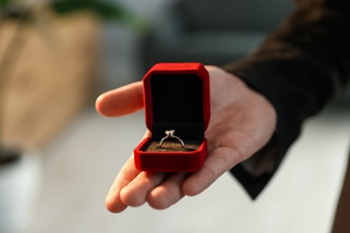 Photo of Making proposal. Man with engagement ring indoors, closeup