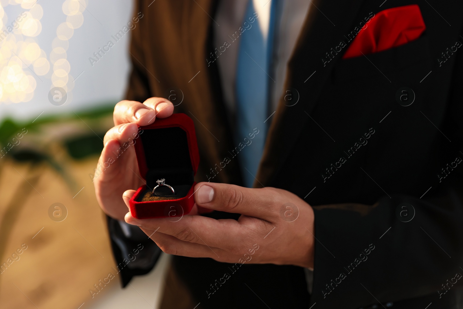 Making proposal. Man with engagement ring indoors, closeup. Bokeh effect Photo of Making proposal. Man with engagement ring indoors, closeup. Bokeh effect