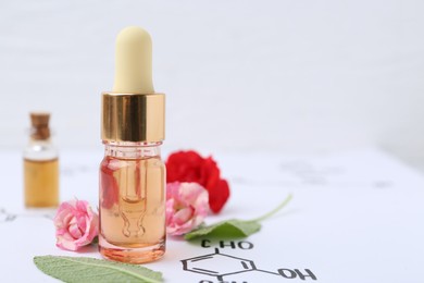 Photo of Bottles of cosmetic products, herbs and roses on paper with chemical formulas, closeup. Space for text